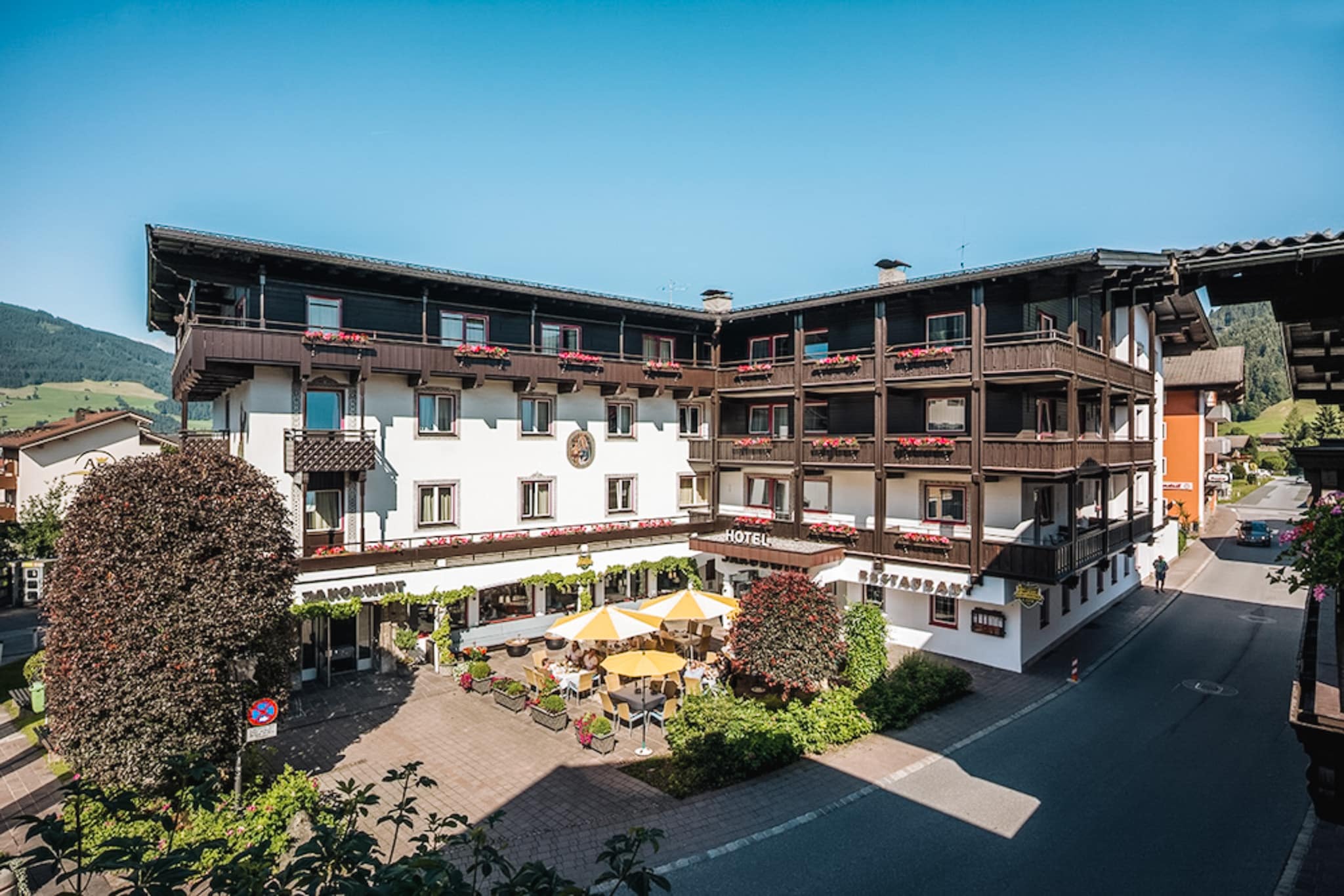 Zomerzicht op de gevel van Alpenhotel Jakobwirt in het hart van Westendorf.